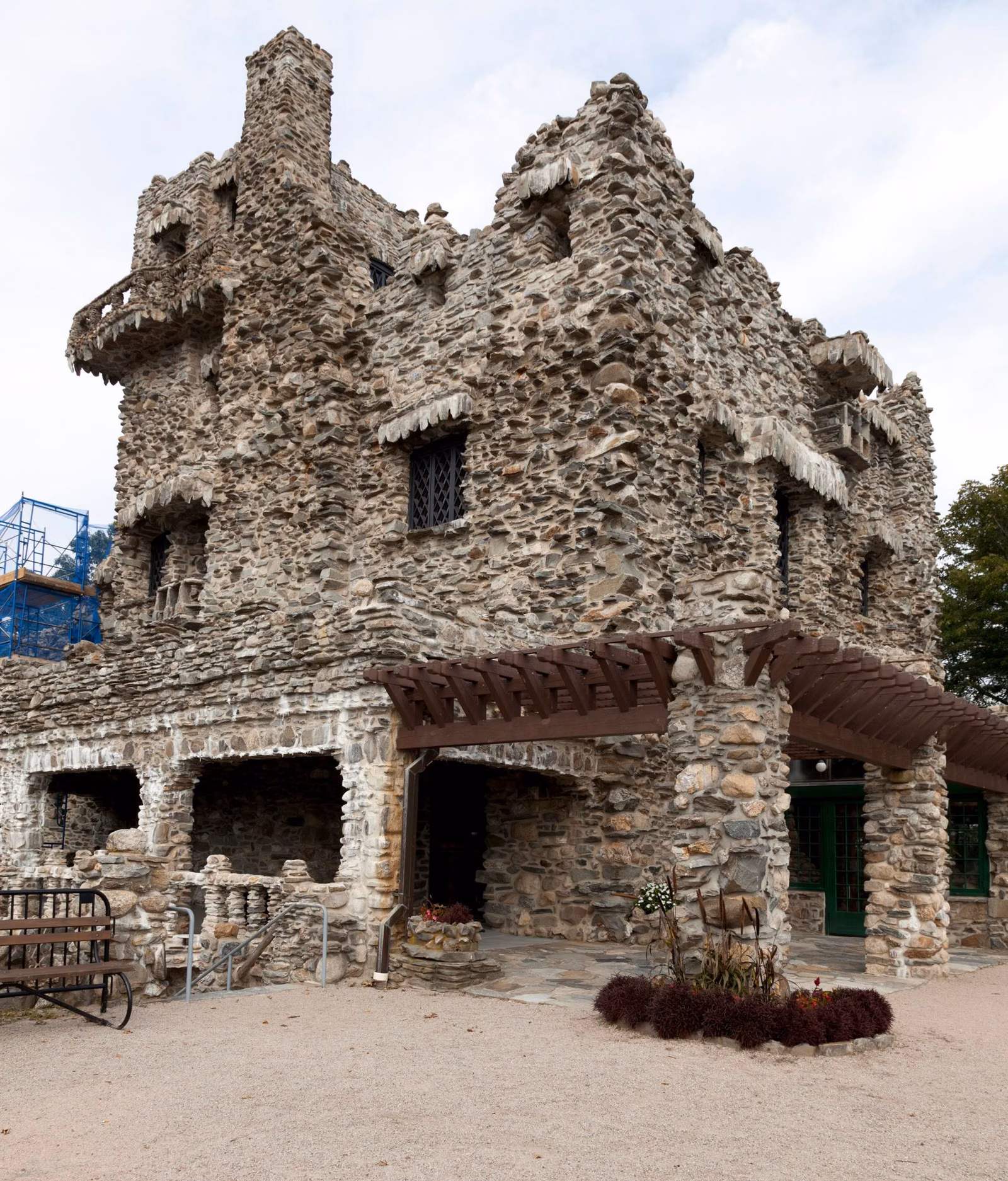 Fieldstone castle walls and towers against a pale sky