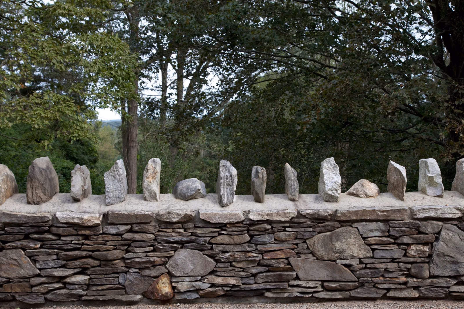 Stacked fieldstone wall topped with upright stones