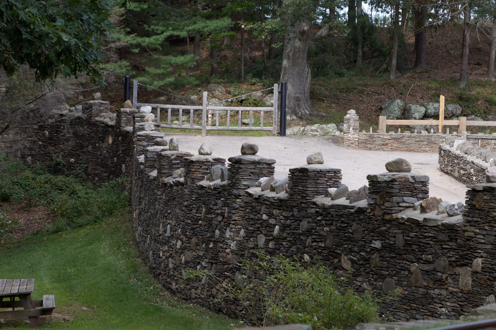 Crenellated fieldstone wall around a gravel terrace