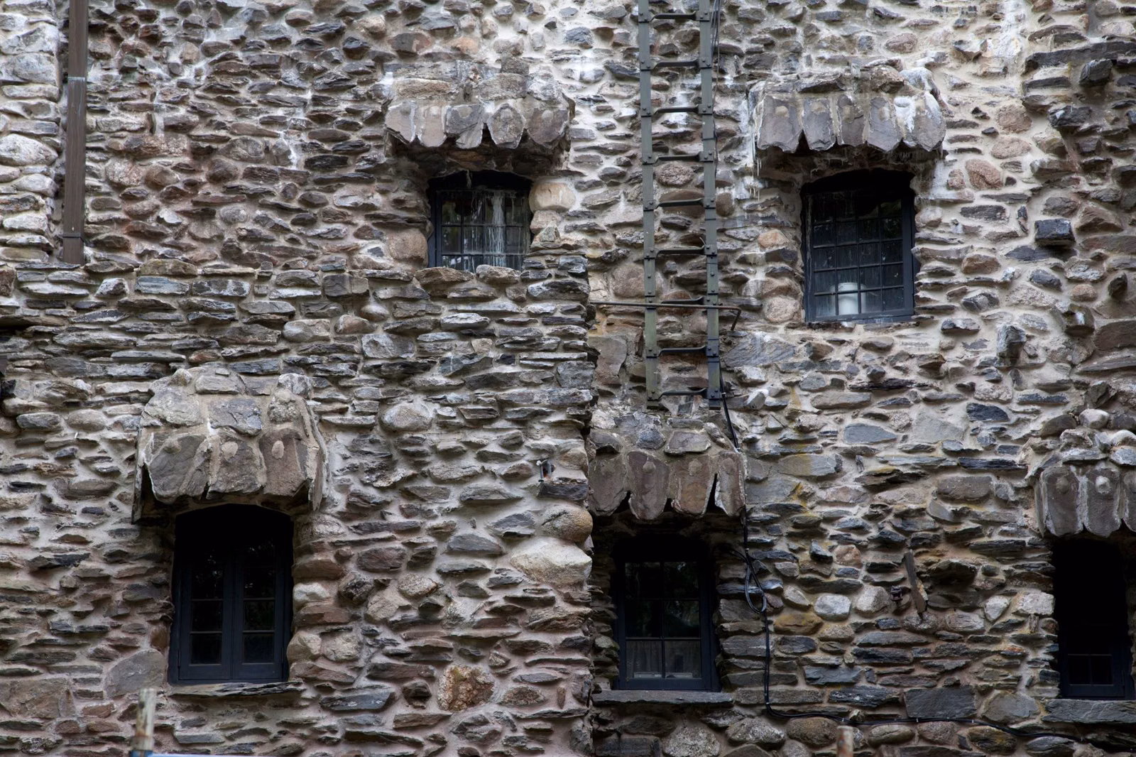 Fieldstone wall with small windows under stone hoods